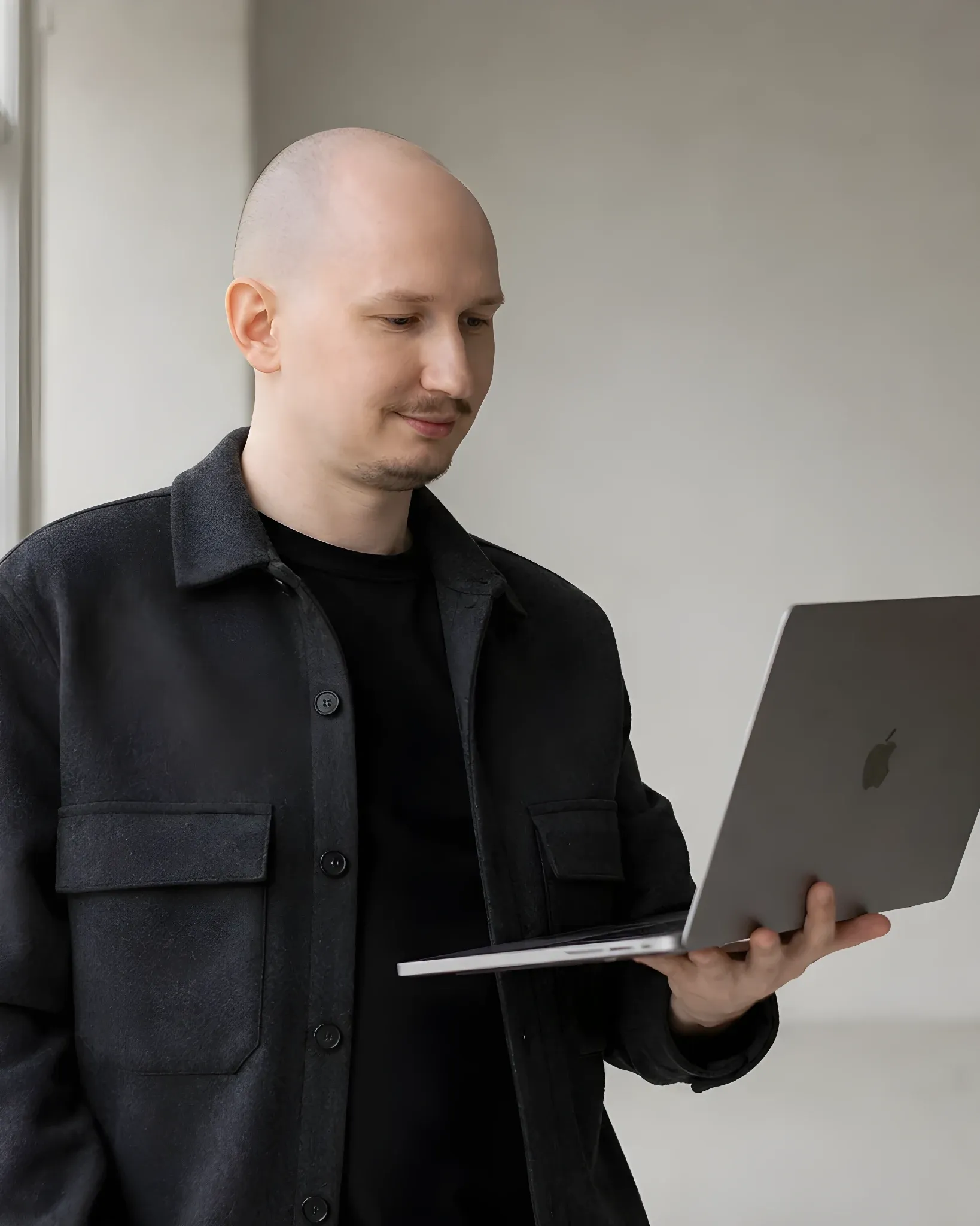 Simon Halimonov, founder of Systems Loop, holding a MacBook