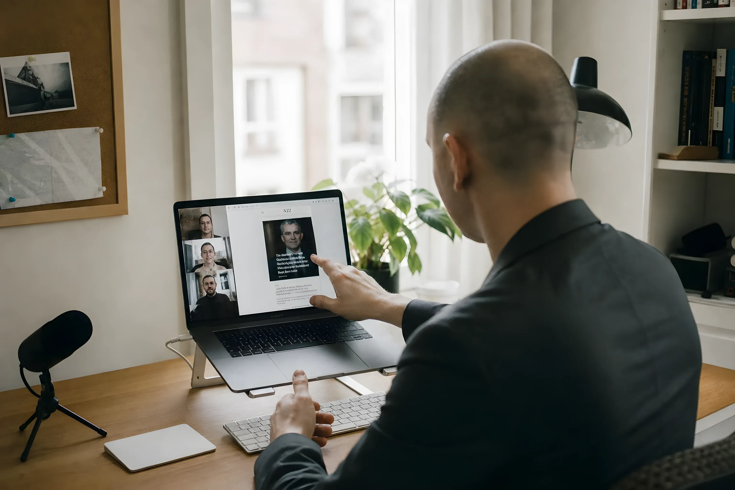 Simon on a video call with the newsroom, pointing at the new NZZ front page on screen